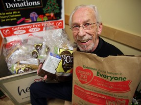 Christmas Cheer Board director Kai Madsen holds groceries during the kickoff of the Safeway/Cheer Board grocery bag program at a press conference in Winnipeg, Man. Tuesday December 01, 2015.