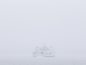 The Wolfe Islander III emerges from the drizzle as it approaches Kingston on Tuesday. The Weather Network expects temperatures to be above normal this December. (Elliot Ferguson/The Whig-Standard)