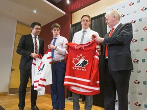 Ryan Jankowski (left), Hockey Canada's director of player personnel along with Tim Speltz (right), Hockey Canada's program of excellence management, present jerseys to Mitchell Marner (white jersey) and Lawson Crouse (red jersey) after announcing the 30 players invited to attend Canada's national junior team selection camp during a press conference at the MasterCard Centre in Toronto on Tuesday, Dec. 1, 2015. (Ernest Doroszuk/Toronto Sun)