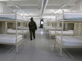 A member of the Canadian Armed Forces walk inside one of the barracks that are being made ready to possibly house Syrian refugees at CFB Trenton in Trenton, Ont., on Tuesday Dec. 1, 2015. CFB Trenton has room for 950 people on base. THE CANADIAN PRESS/Lars Hagberg