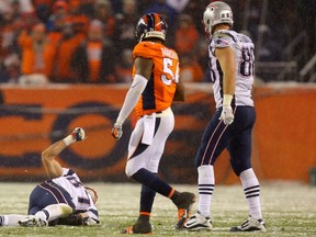 Tight end Rob Gronkowski of the New England Patriots lies on the field injured while inside linebacker Brandon Marshall of the Denver Broncos and tight end Scott Chandler of the New England Patriots look on in the fourth quarter at Sports Authority Field at Mile High on November 29, 2015 in Denver, Colorado. (Justin Edmonds/AFP)