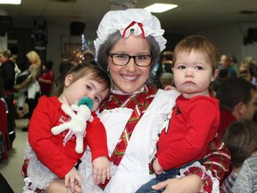 One year old twins Paislee and Jacob Hoogenhoud got to meet Ms. Santa and later they had their picture taken with Old St. Nick himself at the La Ruche Community Christmas Party held on Saturday. The two children were among hundreds who attend the 11th annual event. See page 13 for more photos.