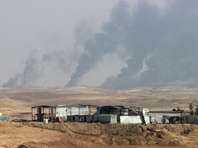 In this Oct. 24, 2015, file photo, smoke rises as Iraqi security forces and allied Popular Mobilization Forces shell Islamic State group positions at an oil field outside Beiji, some 250 kilometers north of Baghdad, Iraq. The United States has stepped up the bombing of the Islamic State militant group's oil operations. (AP Photo, File)