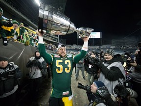 Edmonton Eskimos' Ryan King is surrounded by photographers as he hoists the Grey Cup trophy after defeating the Ottawa Redblacks to win the 103rd Grey Cup in Winnipeg, Man., Sunday, Nov. 29, 2015. THE CANADIAN PRESS/Darryl Dyck