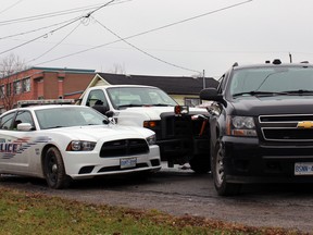 Const. Richard Hough, Kingston Police collision reconstructionist, examines the scene after a 31-year-old woman allegedly stole a City of Kingston truck then fled pursuing officers in Kingston, Ont. on Wednesday December 2, 2015. Steph Crosier/Kingston Whig-Standard/Postmedia Network