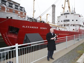 Chris West, chair of the board of the Marine Museum of the Great Lakes, helps unveil an information panel that is part of a new outdoor exhibition about the Kingston Dry Dock. (Elliot Ferguson/The Whig-Standard)