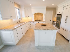 A traditional bright white kitchen, paired with a creamy quartz countertop and neutral floor. (Designer: Cassandra Nordell/Copyright William Standen Co. 2015)