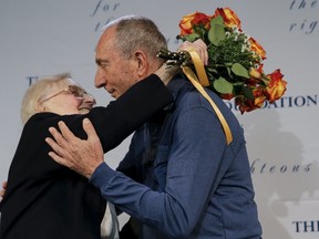 Rescuer Krystyna Jakubowska (L) and holocaust survivor Michael Hochberg hug on stage during a ceremony after arriving from Israel at John F. Kennedy airport in the Brooklyn borough of New York December 2, 2015. Survivor Hochberg of Israel and rescuer, Jakubowska of Poland, have been brought back together by The Jewish Foundation for the Righteous. REUTERS/Mike Segar