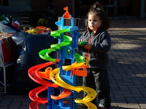 Zenos Istefan, 2, plays with a toy on his driveway while his family packs up to move. (MORRIS LAMONT, The London Free Press)