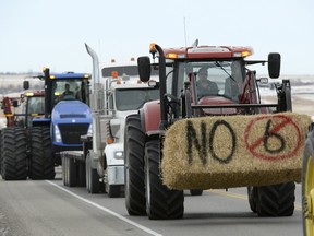 A long convoy of farmers and ranchers driving tractors, sprayers, combines and trucks travel from Fort Macleod north on Highway 2 to Okotoks December 2, 2015 where they will be meeting with provincial Labour Minister Lori Sigurdson and Agriculture Minister Oneil Carlier. Alberta's government will retool a bill that would overhaul workplace standards on farms in Canada's biggest cattle-producing province, its agriculture minister said, after protests by farmers and ranchers.  REUTERS/Mike Sturk