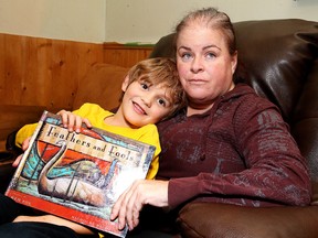Crystal Courtemanche and her six-year-old son Steeven show off a book in Sudbury, Ont. on Wednesday December 2, 2015. Gino Donato/Sudbury Star/Postmedia Network