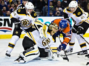 Anton Lander crashes the net as Bruins goalie Tuuka Rask pounces on the puck during the first period of Wednesday's game at Rexall Place. (Codie McLachlan, Edmonton Sun)
