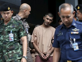 A suspect of the August 17 Bangkok blast, who has been referred to as Yusufu Mieraili, is escorted by soldiers and prison officers as he leaves the military court in Bangkok, Thailand, November 24, 2015. A Thai military court has indicted two men accused of carrying out a Bangkok bomb attack that killed 20 people including 14 foreigners, making it the deadliest such incident in Thai history. A lawyer for one of the men said a Bangkok military court brought ten charges against the pair, including premeditated murder, illegal possession of weapons and murder.  REUTERS/Chaiwat Subprasom