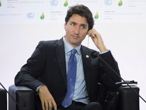 Prime Minister Justin Trudeau adjusts his translation aid as he listens to speakers during a session on carbon pricing at the United Nations climate change summit, Monday November 30, 2015 in Le Bourget, France. THE CANADIAN PRESS/Adrian Wyld