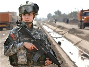 U.S. soldier Pfc. Janelle Zalkovsky, from civil affairs unit of 1st Battalion, 320th Field Artillery Regiment, 101st Airborne Division, provides security while other soldiers survey a newly constructed road in Ibriam Jaffes, Iraq in  this handout photo released on December 7, 2005. U.S. Defense Secretary Ash Carter on December 3, 2015 announced the U.S. military will open all combat jobs to women. REUTERS/U.S. Srmy/Handout