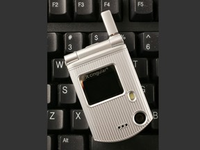 In this March 8, 2007, file photo, a C3 flip phone from Pantech is shown, on a keyboard for size comparison, in New York. More than 90% of smartphone users trade up for newer models within two years, according to experts. But a fraction of the population continues to cling to older phones, some three to four years old, or more. (AP Photo/Mark Lennihan, File)