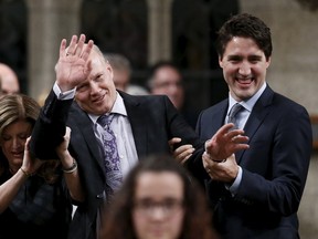 New Speaker of the House of Commons Geoff Regan (C) joking resists while being escorted by Canada's Prime Minister Justin Trudeau (R) and Conservative interim leader Rona Ambrose in the House of Commons on Parliament Hill in Ottawa, Canada December 3, 2015. REUTERS/Chris Wattie