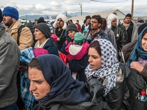 Migrants wait to board a train after crossing the Greek-Macedonian border, near Gevgelija, on December 2, 2015. 
Some three-kilometre (1.8-mile) long metal fence was erected by the army at the Gevgelija crossing, on the main road north from the Greek city of Thessaloniki to Macedonia's capital Skopje. The border will remain open and only people who are not from war-affected regions will not be allowed to cross, spokesman Aleksandar Gjorgjev told AFP.  / AFP / ARMEND NIMANI