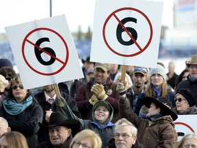 People hold signs protesting Bill 6 in a meeting with provincial Labour Minister Lori Sigurdson and Agriculture Minister Oneil Carlier in Okotoks December 2, 2015. Alberta's government will retool a bill that would overhaul workplace standards on farms in Canada's biggest cattle-producing province, its agriculture minister said, after protests by farmers and ranchers.  (REUTERS/Mike Sturk )