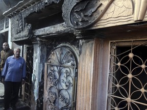 People look at the restaurant that was attacked in Cairo, Egypt, December 4, 2015. A Molotov cocktail hurled at the Cairo restaurant killed 16 people and wounded two on Friday, Egyptian security officials said. (REUTERS/Mohamed Abd El Ghany)