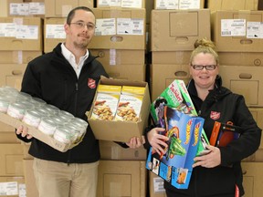 Donated food and toys will go a long way in helping make Christmas a bit brighter this year. Neil Sunnuck and Amanda Mueller of the Tillsonburg Salvation Army hold some of the donated items that will distributed to individuals and families in need this holiday season. Behind them are hundreds of boxes that will be filled with the items in the coming weeks. KIM NOVAK/TILLSONBURG NEWS