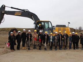 Digging in for a great celebration! Halminen Homes broke ground on The Villas of McLaughlin Heights, last Friday, Nov. 27. Pictured (l-r) Anu Thorne, Dianne Linkie, Sylvia Dias, Ben Davis, Graham Hill, Joe Neal, Mayor Adrian Foster (in the backhoe) Hannu Halminen, Steve Cook, Wendy Partner, Heidi Stephenson, Willie Woo, Ryan Topple, Jennifer Francisco, Mette Conners, Lori Halvorson and Anita Cheung.