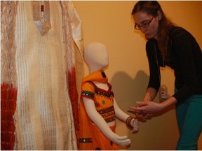 This Diwali display in Huron County Museum’s temporary exhibition gallery is part of "Celebrations," an exhibit dedicated to winter holiday traditions. The objects in this display were brought to the museum from Bangalore, India. Sinead Cox, education and programming assistant, places bangles on a mannequin in the Huron County Museum’s Diwali display. (Contributed photo)