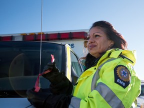 Paramedic of more than 15 years, Tracy Buffalo ties a red ribbon to her emergency vehicle during the launch of Mother’s Against Drunk Driving (MADD) Parkland chapter Red Ribbon campaign at the Parkland Funeral Home in Stony Plain on Wednesday, Nov. 18. - Yasmin Mayne, Reporter/Examiner