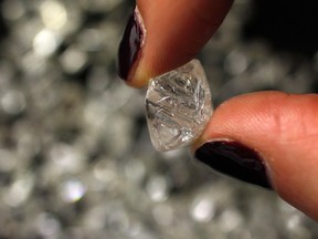 A women holds an uncut diamond at De Beers headquarters in London January 17, 2011. (REUTERS/Stefan Wermuth)
