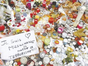 A message which reads, ?I am a Muslim and against terrorism,? is seen among candle tributes to victims near the Bataclan concert hall, one of the sites of deadly attacks, in Paris, France, Nov. 13. Former Londoner Lena Hassan says being Muslim makes it tougher when such attacks occur, as the tendency is to blame all Muslims. (Jacky Naegelen / Reuters)