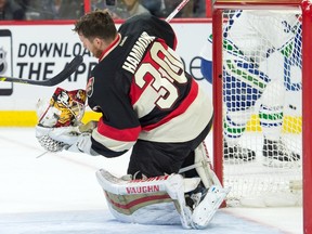 Ottawa Senators goalie Andrew Hammond (30) loses his helmet following a shot on goal in the second period against the Vancouver Canucks at Canadian Tire Centre. Mandatory Credit: Marc DesRosiers-USA TODAY Sports
