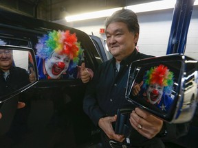 Doo Doo, the hero clown who had his side-view mirror torn off his SUV while rescuing two women in downtown Toronto last month, received a new one from  Birchmount Collision owner Wayne Hosaki. (Jack Boland/Toronto Sun/Postmedia Network)