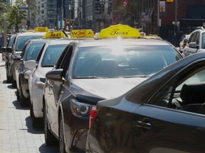 Taxi drivers are pictured as they line up for fares in front of Union Station. Upset with Uber, cabbies vow to clog streets in protest next Wednesday in protest. (STAN BEHAL, Toronto Sun)