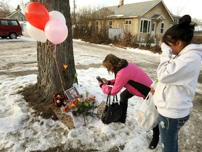 Women are seen at a makeshift memorial near Duster's Pub, where a man was found shot outside the building. (EDMONTON SUN/File)