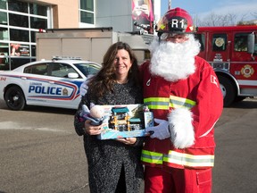 Marisa Thorburn of the London police department?s victim services unit and Randy Evans of the London fire department encourage citizens to participate in their Christmas toy drive Saturday. (DEREK RUTTAN, The London Free Press)