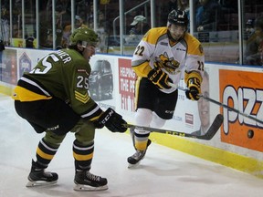Sarnia Sting forward Matt Mistele chips the puck past North Bay Battalion defenceman Mark Shoemaker during the Ontario Hockey League game at the Sarnia Sports and Entertainment Centre. Mistele picked up an assist in his Sting debut after being acquired in a trade earlier this week from Oshawa. Terry Bridge/Sarnia Observer/Postmedia Network