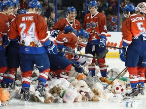 The Edmonton Oil Kings pose for a photo with dozens of donated bears for 630 CHED Santas Anonymous on the ice after Edmonton centre Andrew Koep (15) scored the Teddy Bear Toss goal during the first period of a WHL hockey game between the Edmonton Oil Kings and the Moose Jaw Warriors at Rexall Place in Edmonton, Alta., on Saturday, Dec. 6, 2014. Ian Kucerak/Edmonton Sun/ QMI Agency
