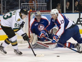 Windsor Spitfires defenceman Logan Stanley dives as he tries to keep London Knights forward Mitch Marner from reaching a loose puck in front of Spitfires goaltender Garret Hughson during their OHL hockey game at Budweiser Gardens in London, Ont. on Friday December 4, 2015. (CRAIG GLOVER, The London Free Press)