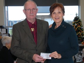 Norm Knott, president of the St. Thomas Duplicate Bridge Club, left, presents a $500 donation to Christmas Care volunteer Lindsay Sleightholm. The donation will help the local non-profit supply food hampers and presents to families in need across Elgin county this holiday season.