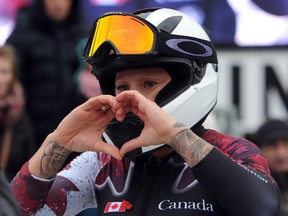 Kaillie Humphries of Canada makes a heart shape with her hands as she celebrates her third place finish in the World Cup bobsled event in Winterberg, Germany, Saturday Dec, 5, 2015. (Caroline Seidel/dpa via AP)
