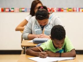 Students in Krista Long's Grade 8 and 9 ESL class work before a news conference with Alberta Education Minister David Eggen at St. Catherine Catholic School in Edmonton, Alta., on Tuesday September 1, 2015. The minister answered questions about school construction, the provincial budget and restored educational funding. Ian Kucerak/Edmonton Sun/Postmedia Network