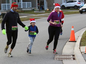 Andy, Euan and Pam Goodspeed finish the Santa Shuffle Fun Run and Elf Walk together in Kingston, Ont. on Saturday December 5, 2015. Steph Crosier/Kingston Whig-Standard/Postmedia Network