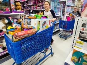 (left to right) Ellie Masters, 11, and Hallie Park, 11, push shopping carts full of toys through Toys R Us, 3940 Gateway Blvd., during the Kinsmen Club of Edmonton's 8th Annual Toy Blitz in support of Santas Anonymous, in Edmonton, Alta. on Saturday Dec. 5, 2015. David Bloom/Edmonton Sun/Postmedia Network