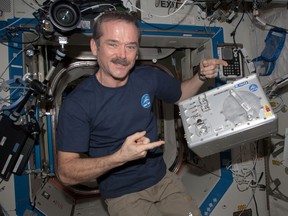 Chris Hadfield shows off the Microflow device on board the ISS.
(Credit: NASA)
