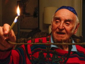 Monty Mazin, 88,  lights the first candle to mark the start of Hannukah in his North York home on Sunday. (DAVE THOMAS, Toronto Sun)