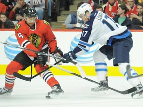 Dec 6, 2015; Chicago, IL, USA; Chicago Blackhawks defenseman Trevor Daley (6) and Winnipeg Jets left wing Adam Lowry (17) battle for the puck during the second period at United Center. Mandatory Credit: Patrick Gorski-USA TODAY Sports