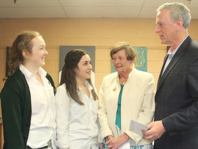 Holy Cross Catholic Secondary School students Olivia Lynch, left, and Anna Stafford, at their school in Kingston, Ont. on Monday, Dec. 7, 2015, present cheques totalling $1,000 to Mary Campeau and Mike Gallagher from the St. Paul the Apostle church refugee sponsorship committee to help support a Syrian family coming to Kingston this week. Michael Lea/The Whig-Standard/Postmedia Network