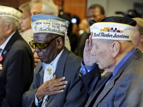 Pearl Harbor survivors (L to R) Armando Gallela, Clark Simmons, and Aaron Chabin salute during a singing of the Star Spangled Banner during a ceremony on the Intrepid Sea, Air, & Space Museum to commemorate the 74th anniversary of the surprise attack on Pearl Harbor, in New York Dec. 7, 2015. REUTERS/Lucas Jackson