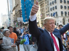 In this Sept. 24, 2015, file photo, Republican presidential candidate Donald Trump waves to the crowd gathered in front of Trump Tower ahead of the arrival of the pope's motorcade for an appearance in New York's Central Park. (AP Photo/Kevin Hagen, File)