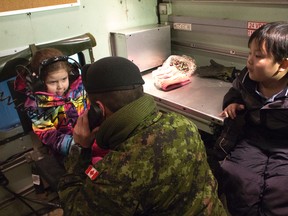 Alexis (left) waits to hear Santa on the radio as Anthony (right) waits his turn. Operation Radio Santa was set up at Burtrand E. Glavin school on Dec. 7 by the 38 Canadian Brigade Group.